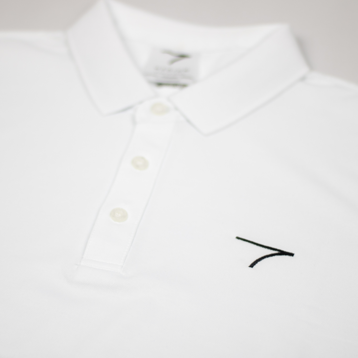 Close Up White Polo Fable Logo on Golf Polo